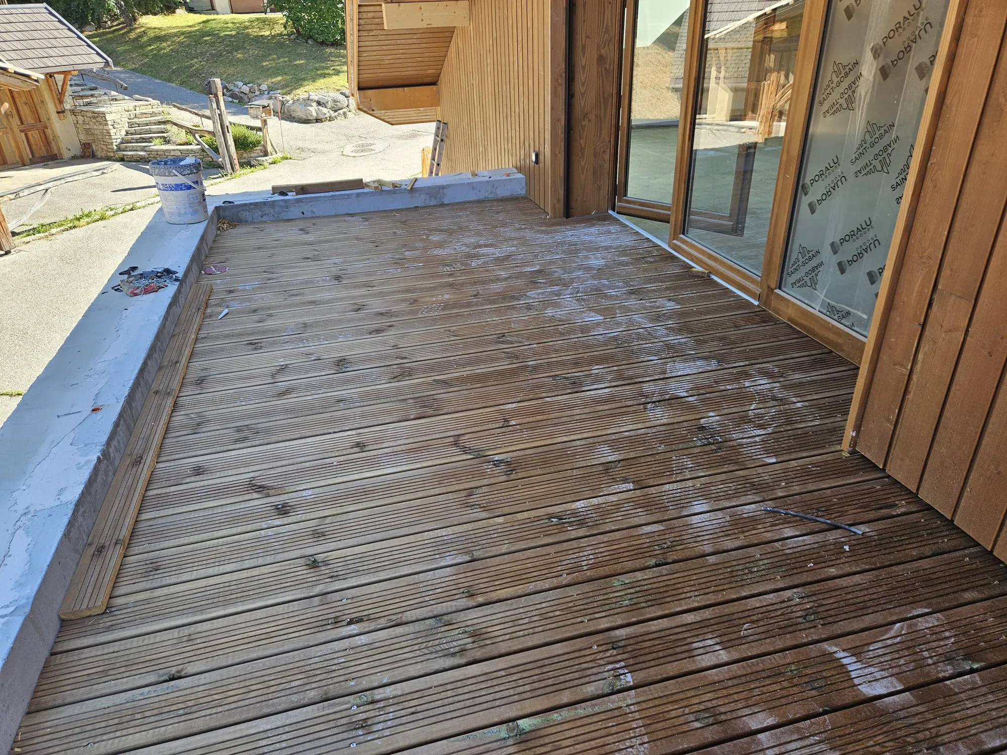 Terrasse bois devant une baie vitrée