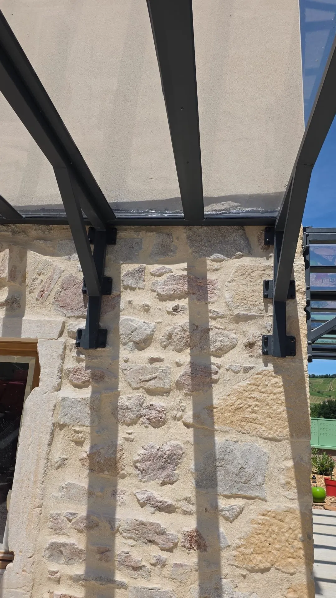 Fixation sur platines scellées dans le mur en pierre
