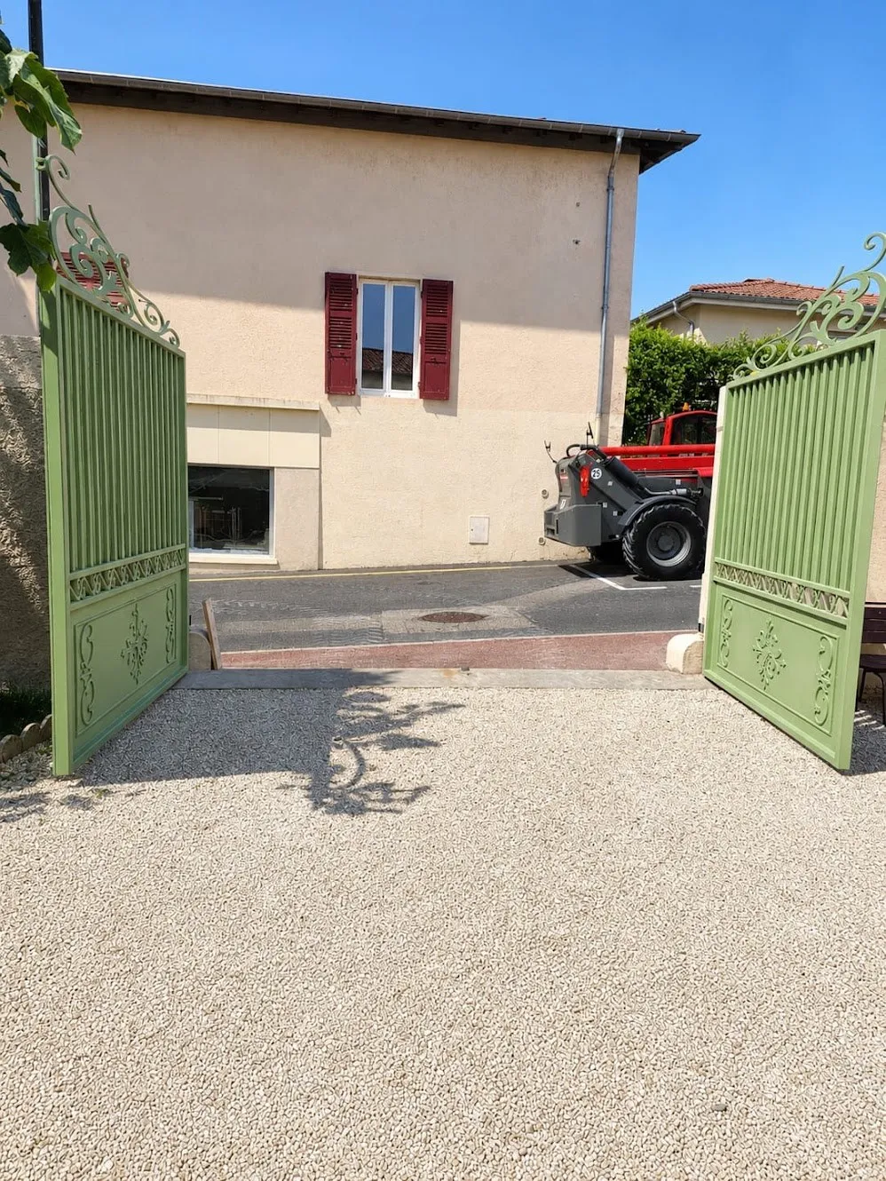 Portail acier deux vantaux vert sur allée gravillonnée