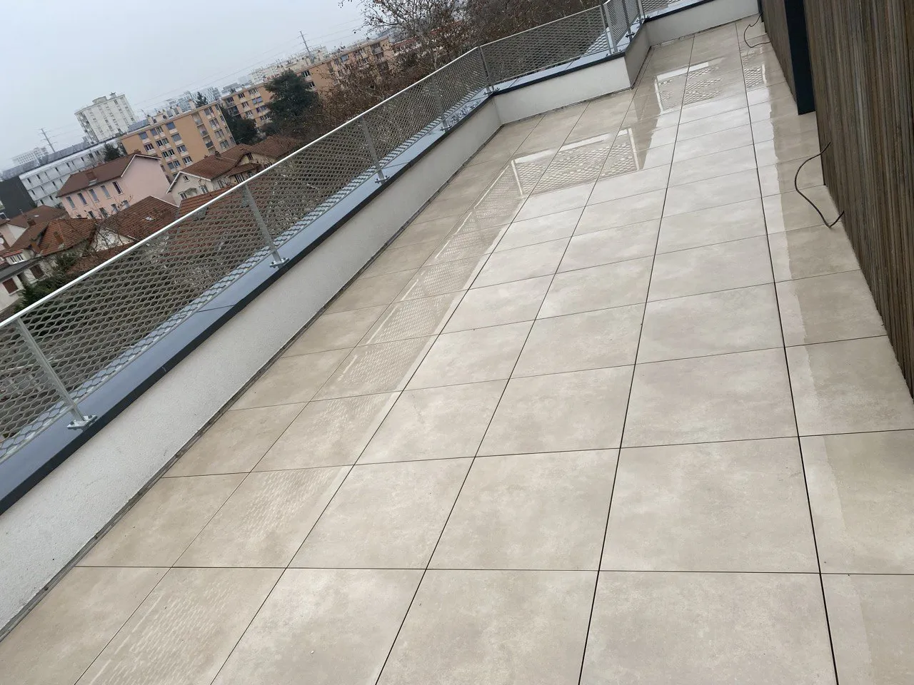 Terrasse en dalles beiges et garde-corps à câbles